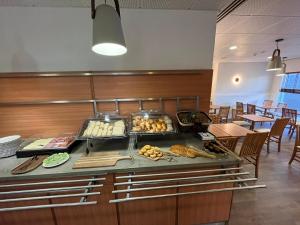 a buffet in a restaurant with some food on it at Flag Hotel Lisboa Oeiras in Oeiras