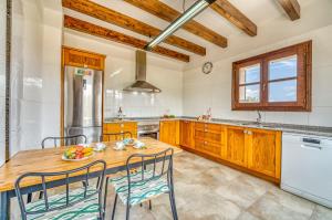 a kitchen with a wooden table and chairs at Ideal Property Mallorca - Sa Pleta in Petra