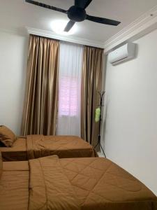 una camera con 2 letti e un ventilatore a soffitto di Kita Impian Residence @ Cybersouth a Kampung Dengkil