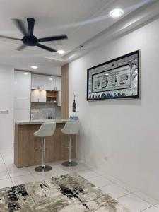 a kitchen with two stools and a ceiling fan at Kita Impian Residence @ Cybersouth in Kampung Dengkil