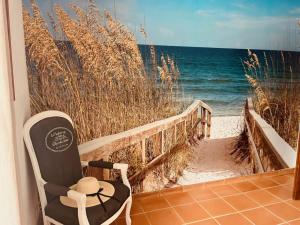 einen Stuhl auf einer Veranda neben dem Strand in der Unterkunft sous le mûrier in Allauch