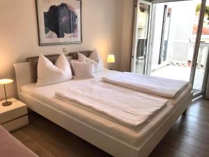 un grande letto con lenzuola e cuscini bianchi in una camera da letto di Villa Diana a Kaštela (Castelli)