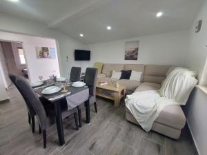 a living room with a table and a couch and a table and chairs at Vila Neyra in Pula