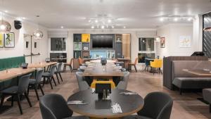 un ristorante con tavoli e sedie in una stanza di Holiday Inn Derby/Nottingham, an IHG Hotel a Derby