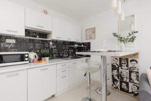 a kitchen with white cabinets and a chalkboard wall at Sweet Underground Studio close to PGE Narodowy by Renters in Warsaw