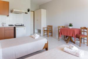 Habitación con 2 camas y cocina con mesa. en Ammousa Hotel Apartments, en Lixouri