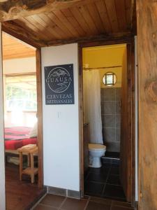 un baño con aseo y un letrero en la pared en El Refugio, Escape Rural, en Gámbita