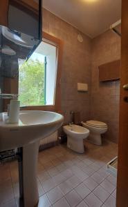 baño con lavabo y aseo y ventana en Agriturismo l'Eremo, en Volpago del Montello