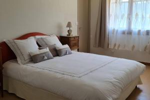 a bedroom with a large white bed with a window at Gîte Le Lion d'Or in Brignoles