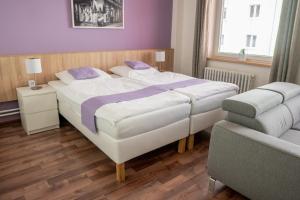 1 dormitorio con 1 cama blanca grande y 1 sofá en Penzion Staré Louny, en Louny