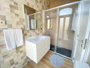 a bathroom with a white sink and a shower at Canto Doce in Setúbal