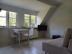 a living room with a couch and a table and windows at Vince appartement Culemborg in Culemborg