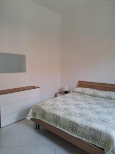 una camera bianca con letto e cassettiera di Il Rio Penise a Pianillo