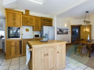 a large kitchen with wooden cabinets and a table at Haslemere - Beer Devon in Beer