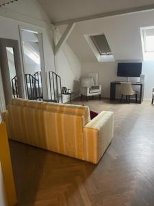 a living room with a yellow couch and a tv at H7 Palace in Prague