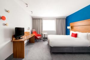 um quarto de hotel com uma cama e uma secretária com uma televisão em Holiday Inn Express Shrewsbury, an IHG Hotel em Shrewsbury
