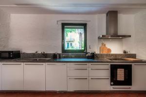 a kitchen with white cabinets and a window at Casa Brocchi by Quokka 360 - unique design house with garden in Sorengo