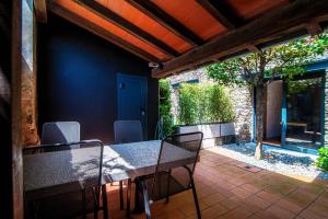 een eettafel en stoelen op een patio bij Casa Brocchi by Quokka 360 - unique design house with garden in Sorengo