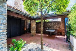 een patio met een tafel en een boom op een patio bij Casa Brocchi by Quokka 360 - unique design house with garden in Sorengo