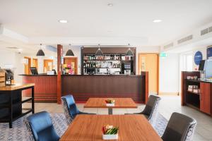 a restaurant with tables and chairs and a bar at Holiday Inn Express Shrewsbury, an IHG Hotel in Shrewsbury