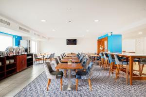uma sala de jantar com mesas e cadeiras de madeira em Holiday Inn Express Shrewsbury, an IHG Hotel em Shrewsbury
