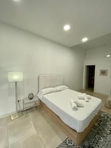 um quarto com uma cama grande e toalhas em El Mosaico Apartment em Valência