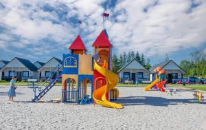 a playground with kids playing on a slide at Domki Letniskowe Biała Perła in Jezierzany