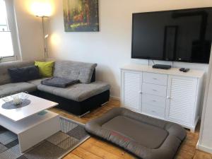 a living room with a couch and a large flat screen tv at Ferienhaus-Am-Eichholz in Ilsenburg