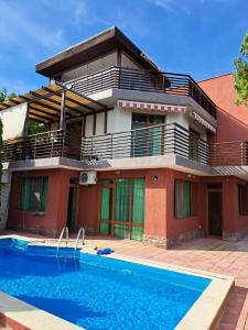 a house with a swimming pool in front of it at Къща за гости '' СКАЙ ВЮ '' in Fish Fish