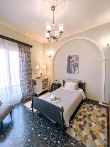 um quarto com uma cama e um lustre em Margaret's house em Corinto