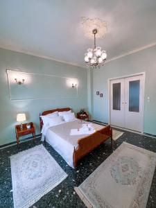 um quarto com uma cama grande e um lustre em Margaret's house em Corinto