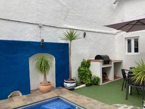 een patio met 2 potplanten en een zwembad bij Traditional Village House with Private Pool in Villanueva de San Juan in Villanueva de San Juan