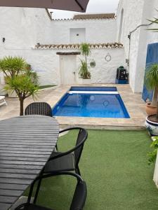 un patio con una mesa y una piscina en Traditional Village House with Private Pool in Villanueva de San Juan, en Villanueva de San Juan