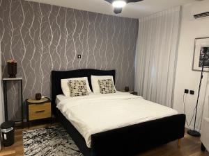 - une chambre avec un lit et un mur aux motifs dans l'établissement דירת בוטיק Dnine7, à Haïfa