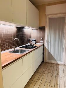 a kitchen with white cabinets and a sink at Roma Suite Trastevere Railway Station in Rome