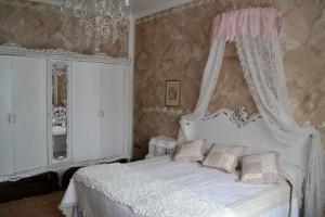 a bedroom with a white bed with a canopy at Le Bouganville Apartment in Desenzano del Garda