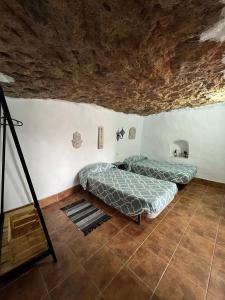 2 Betten in einem Zimmer in einer Höhle in der Unterkunft MIRADOR SAN ROQUE in Las Palmas de Gran Canaria