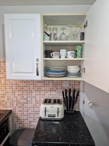 a kitchen counter with a toaster on a counter top at COZY DOUBLE BEDROOM IN ZONE 1-2 CENTRAL LONDON in London