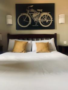 uma cama com duas almofadas e uma foto de uma bicicleta na parede em l'auberge em Gamarde-les-Bains