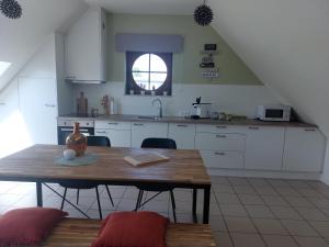 a kitchen with a wooden table and a sink at Ô Baguenaudes in Jalhay