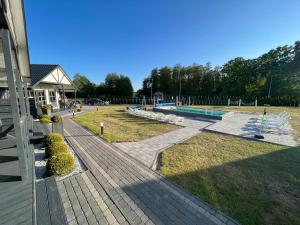 a yard with a swimming pool and a house at Domki Apartamenty Retro in Jarosławiec
