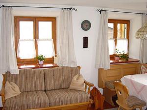 uma sala de estar com um sofá e duas janelas em Ferienwohnung Diechtler em Ruhpolding