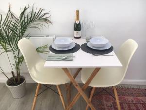 a white table with two chairs and a bottle of wine at Brighton Boutique Garden Studio with Free Parking in Brighton & Hove
