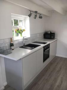 a white kitchen with a stove and a window at Brighton Boutique Garden Studio with Free Parking in Brighton & Hove