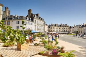 a group of people walking on a street with buildings at A mi-chemin in Vannes