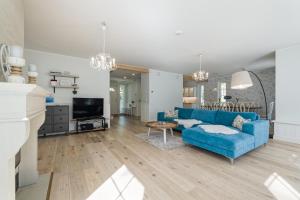 a living room with a blue couch and a tv at Villa de la Mer holiday home in Kaberneeme