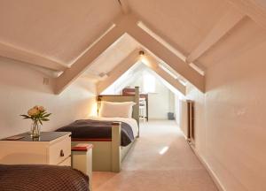 1 dormitorio en el ático con 1 cama y 1 mesa en Ocean Villas, en Marazion