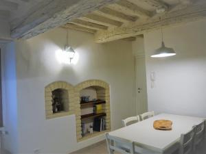a dining room with a white table and a shelf at Casa Marzia in Montevarchi