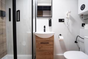 a bathroom with a sink and a shower at Dream Aparts - Piotrkowska 126 widok na deptak in Łódź