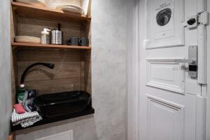 a door to a kitchen with a shelf with dishes at Dream Aparts - Piotrkowska 126 widok na deptak in Łódź +8 photos